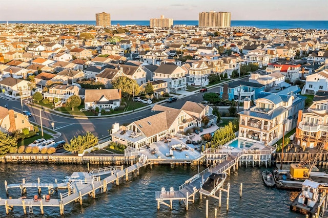 aerial view at dusk featuring a water view