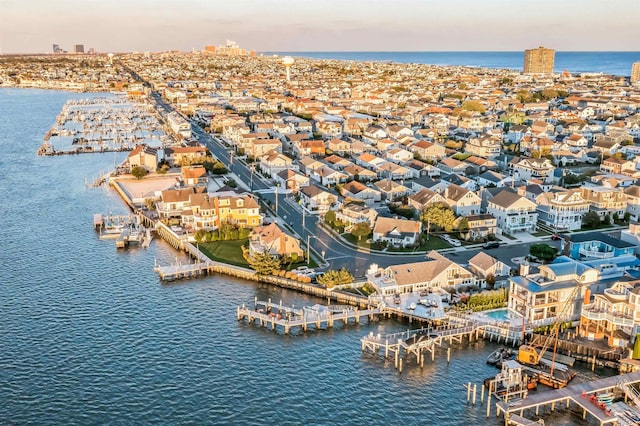 aerial view at dusk featuring a water view