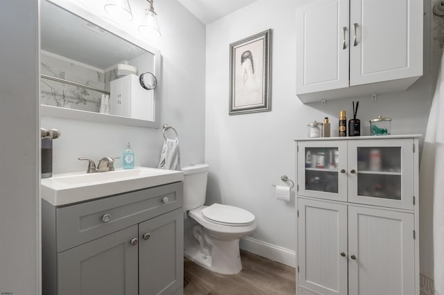 bathroom with vanity, toilet, hardwood / wood-style flooring, and curtained shower