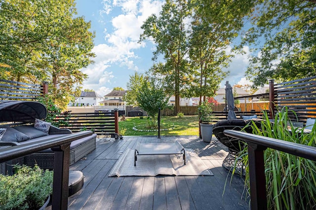 wooden deck with an outdoor hangout area and a yard