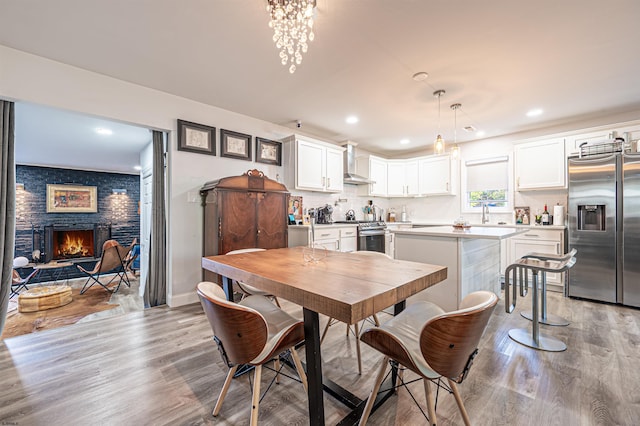 dining room featuring light hardwood / wood-style flooring and a fireplace