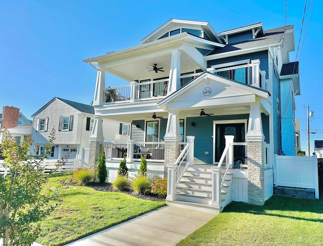 view of front of house with covered porch, a garage, a front yard, and ceiling fan