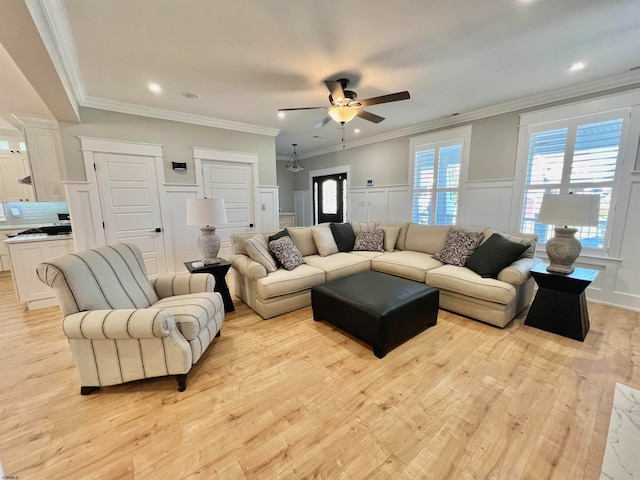 living room featuring crown molding, light wood-type flooring, and ceiling fan