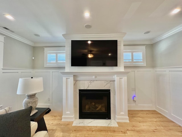 interior details featuring crown molding, hardwood / wood-style flooring, and a fireplace