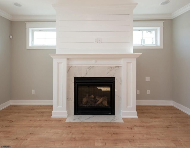 room details with ornamental molding, a high end fireplace, and hardwood / wood-style floors