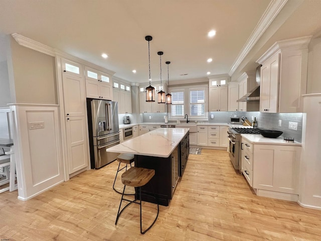 kitchen with appliances with stainless steel finishes, white cabinetry, and a center island