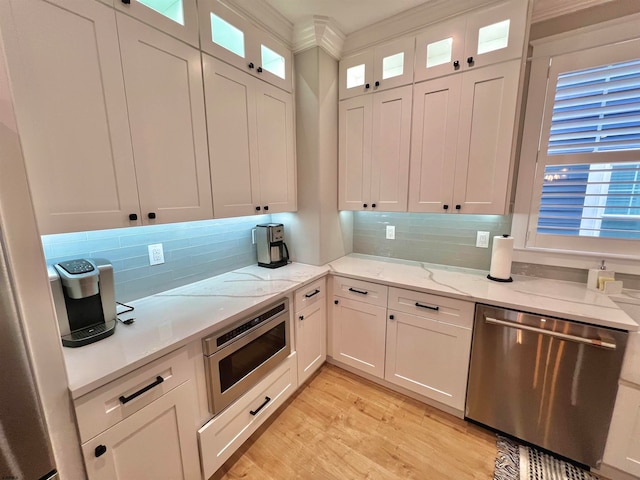 kitchen featuring appliances with stainless steel finishes, crown molding, white cabinets, and light hardwood / wood-style floors