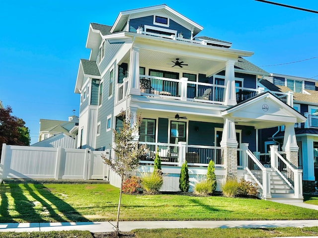 view of front of house with a balcony, covered porch, a front lawn, and ceiling fan