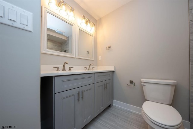 bathroom featuring vanity, toilet, and hardwood / wood-style flooring