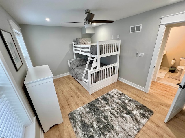 bedroom featuring ceiling fan, ensuite bathroom, and hardwood / wood-style floors