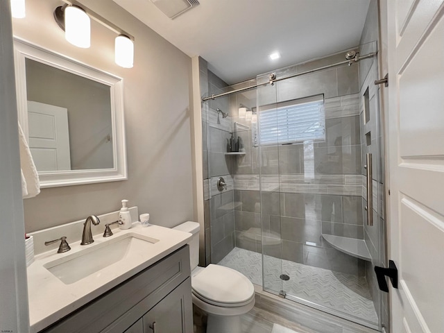 bathroom featuring toilet, an enclosed shower, hardwood / wood-style flooring, and vanity