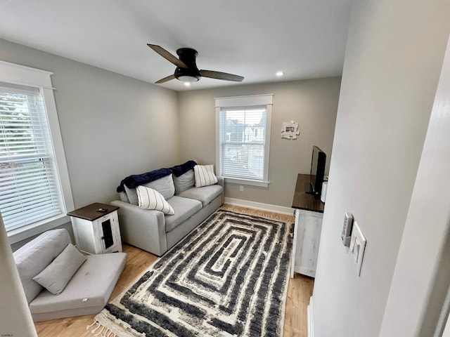 living room with ceiling fan and light wood-type flooring