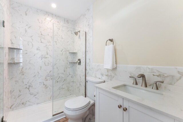 bathroom featuring vanity, toilet, walk in shower, and tile walls