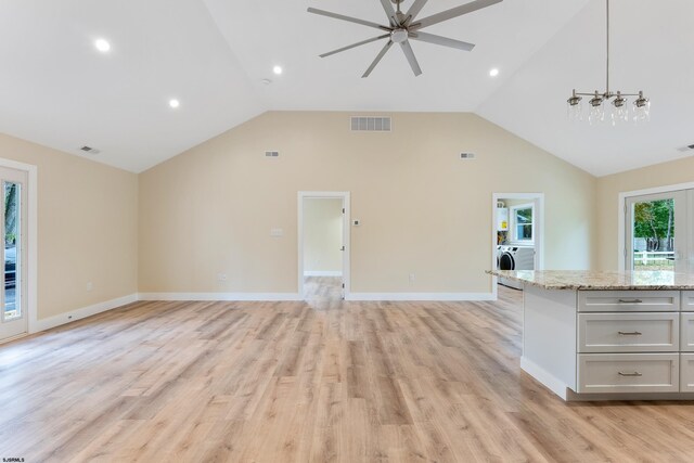 unfurnished living room featuring high vaulted ceiling, ceiling fan with notable chandelier, and light wood-type flooring