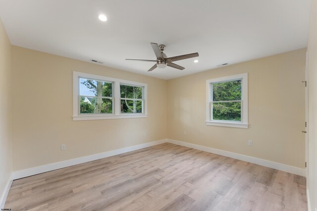 empty room with light hardwood / wood-style flooring, ceiling fan, and plenty of natural light