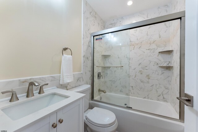 full bathroom with vanity, toilet, and bath / shower combo with glass door