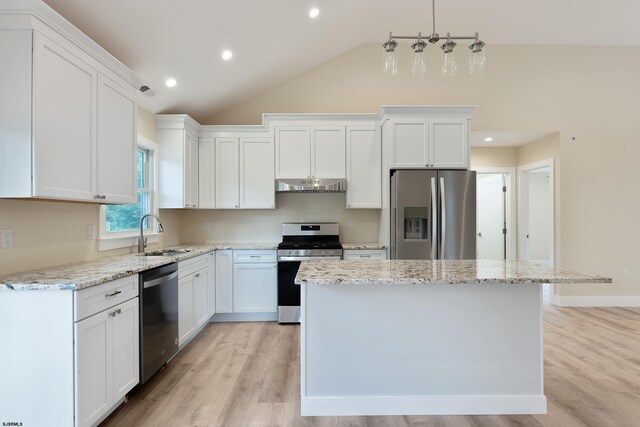 kitchen with a kitchen island, stainless steel appliances, sink, vaulted ceiling, and white cabinetry