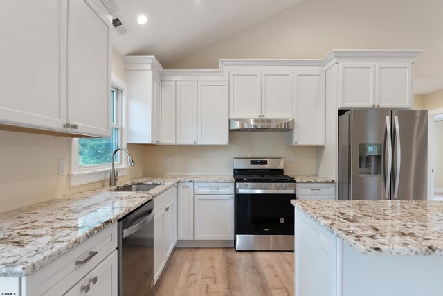 kitchen with appliances with stainless steel finishes, lofted ceiling, white cabinetry, and sink