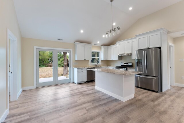 kitchen with appliances with stainless steel finishes, white cabinets, a center island, and hanging light fixtures