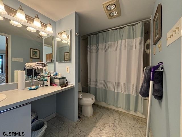 bathroom with toilet, marble finish floor, and vanity