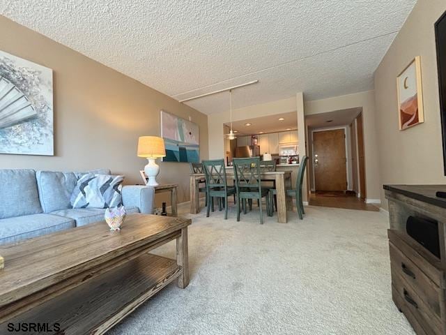 living room featuring light carpet and a textured ceiling