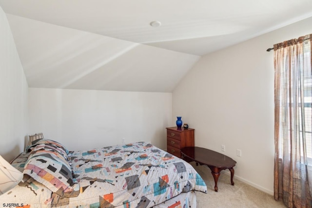 carpeted bedroom with lofted ceiling