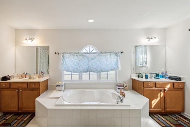 bathroom featuring vanity, tile patterned floors, and tiled tub