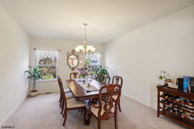 dining area featuring light carpet and a chandelier