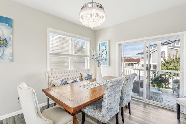 dining area featuring light hardwood / wood-style floors, a notable chandelier, and a healthy amount of sunlight