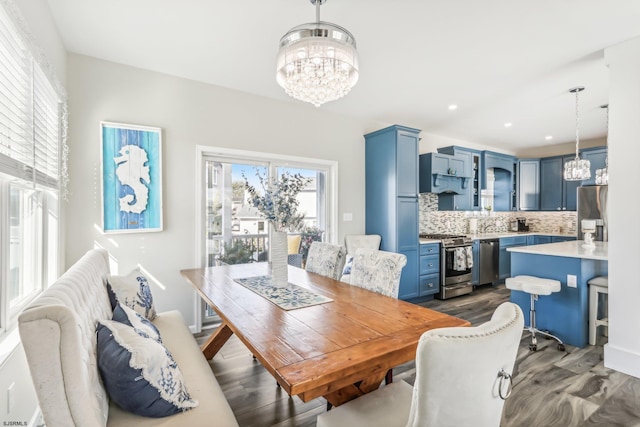 dining area with dark wood-type flooring and an inviting chandelier