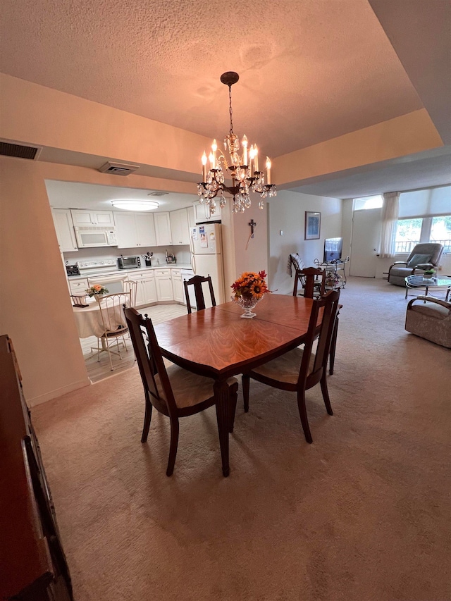 dining area featuring a textured ceiling, light colored carpet, and a chandelier