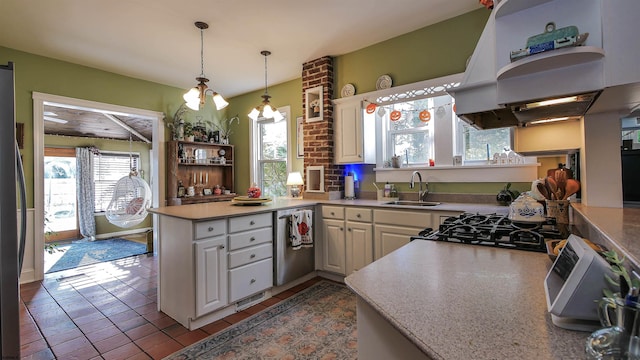 kitchen featuring plenty of natural light, decorative light fixtures, kitchen peninsula, and sink