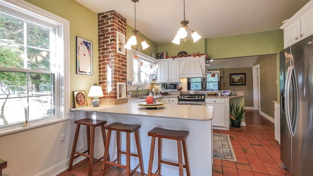 kitchen featuring appliances with stainless steel finishes, kitchen peninsula, and white cabinetry