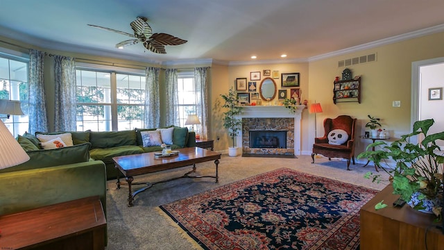 carpeted living room featuring ornamental molding, a fireplace, and ceiling fan