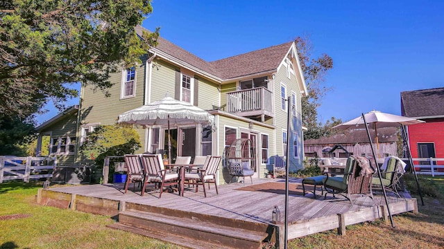 rear view of house with a deck and a balcony