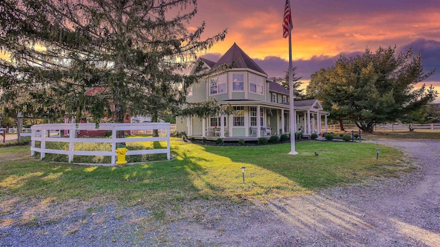 victorian house with a yard and covered porch