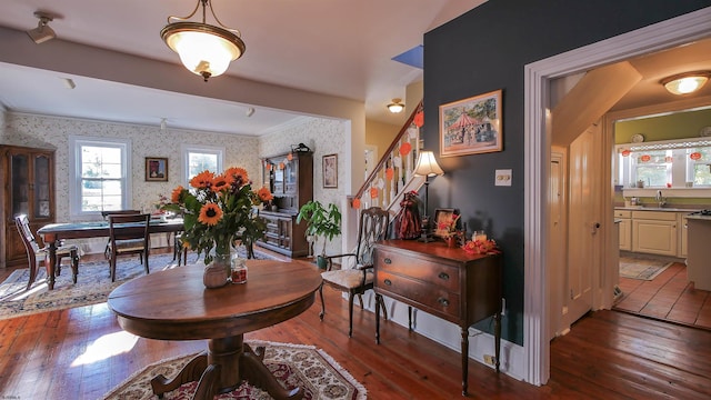 dining area featuring hardwood / wood-style flooring, ornamental molding, and sink