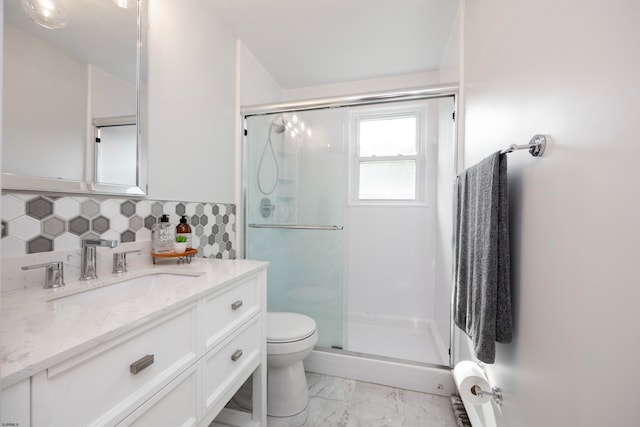 bathroom featuring vanity, tasteful backsplash, toilet, and walk in shower