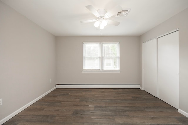 unfurnished bedroom with a baseboard radiator, dark hardwood / wood-style floors, a closet, and ceiling fan