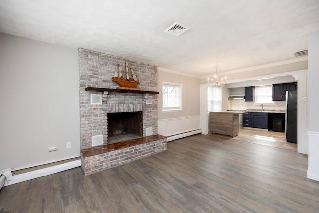 unfurnished living room featuring crown molding, dark hardwood / wood-style floors, a baseboard heating unit, and a brick fireplace