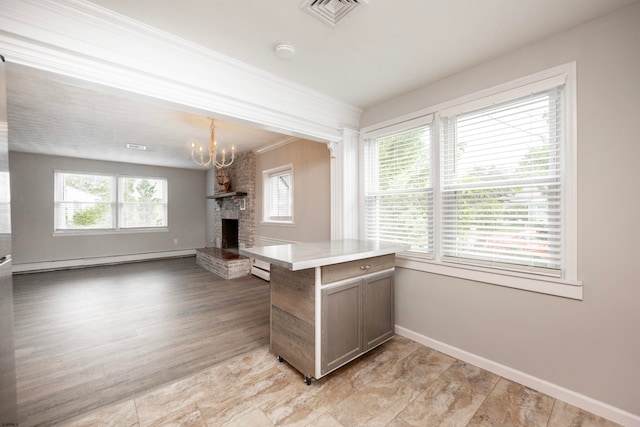 kitchen with kitchen peninsula, baseboard heating, light wood-type flooring, and a wealth of natural light