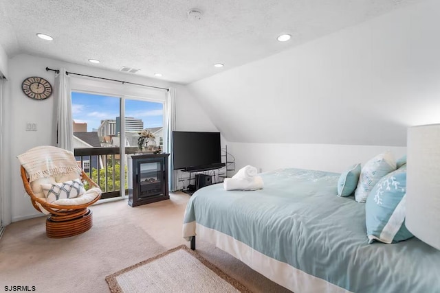 bedroom featuring lofted ceiling, carpet floors, and a textured ceiling