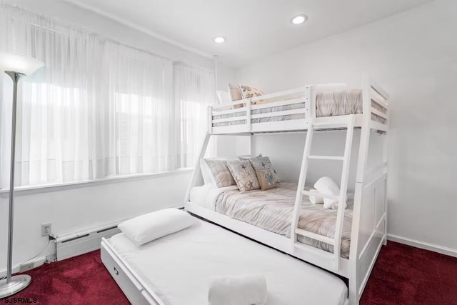 bedroom with carpet flooring and a baseboard heating unit