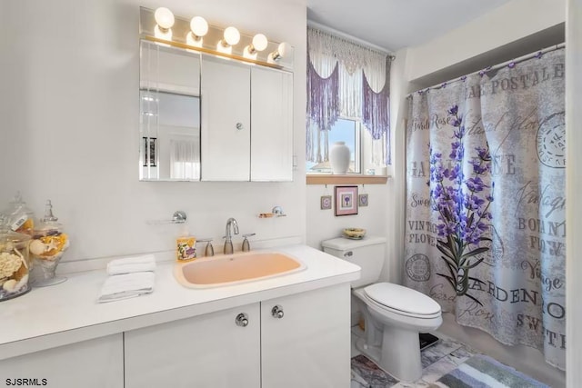 bathroom with vanity, toilet, and curtained shower