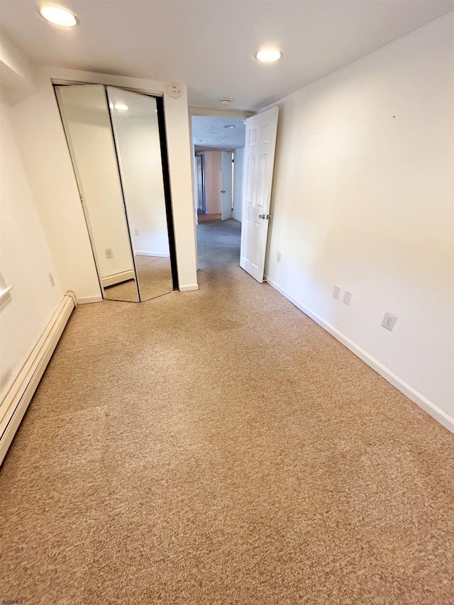 unfurnished bedroom with a baseboard radiator and a closet