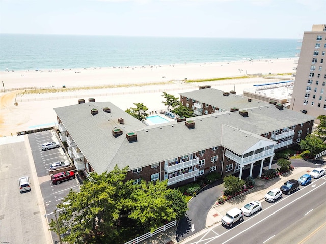 bird's eye view with a water view and a beach view