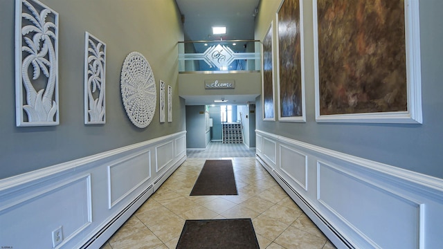 corridor featuring a baseboard radiator and light tile patterned floors