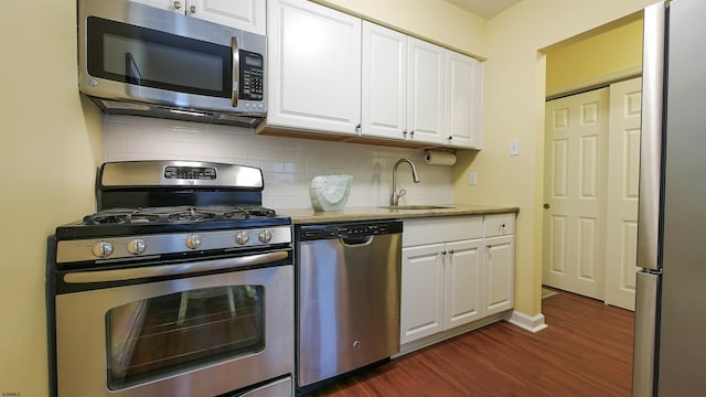 kitchen featuring decorative backsplash, stainless steel appliances, sink, white cabinetry, and dark hardwood / wood-style flooring