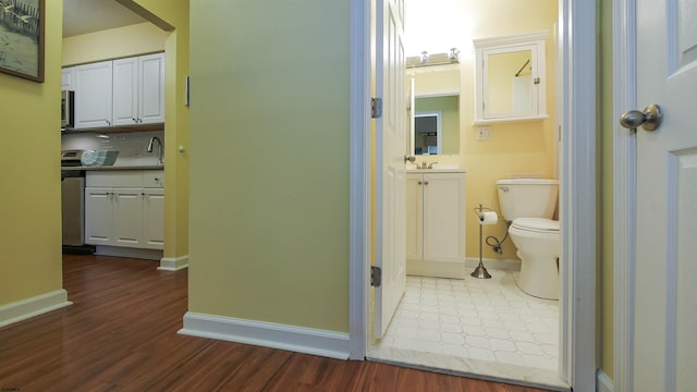 bathroom featuring toilet, wood-type flooring, and sink