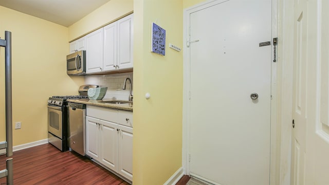 kitchen featuring sink, backsplash, dark hardwood / wood-style flooring, white cabinetry, and stainless steel appliances